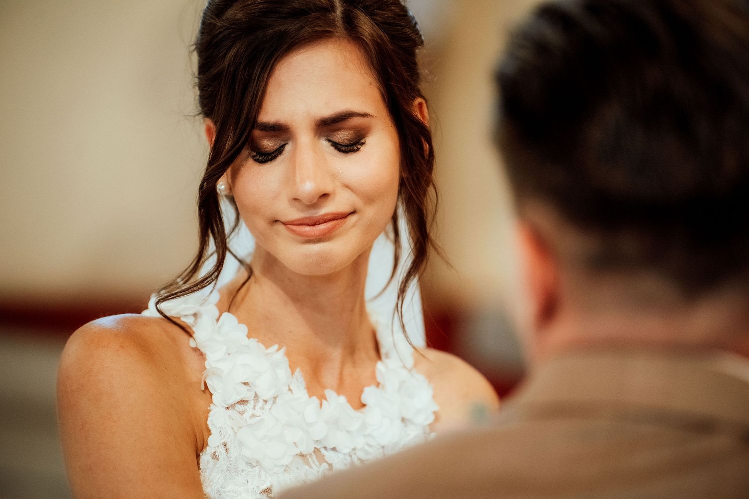 An emotional moment captured during a wedding ceremony in a traditional church setting.