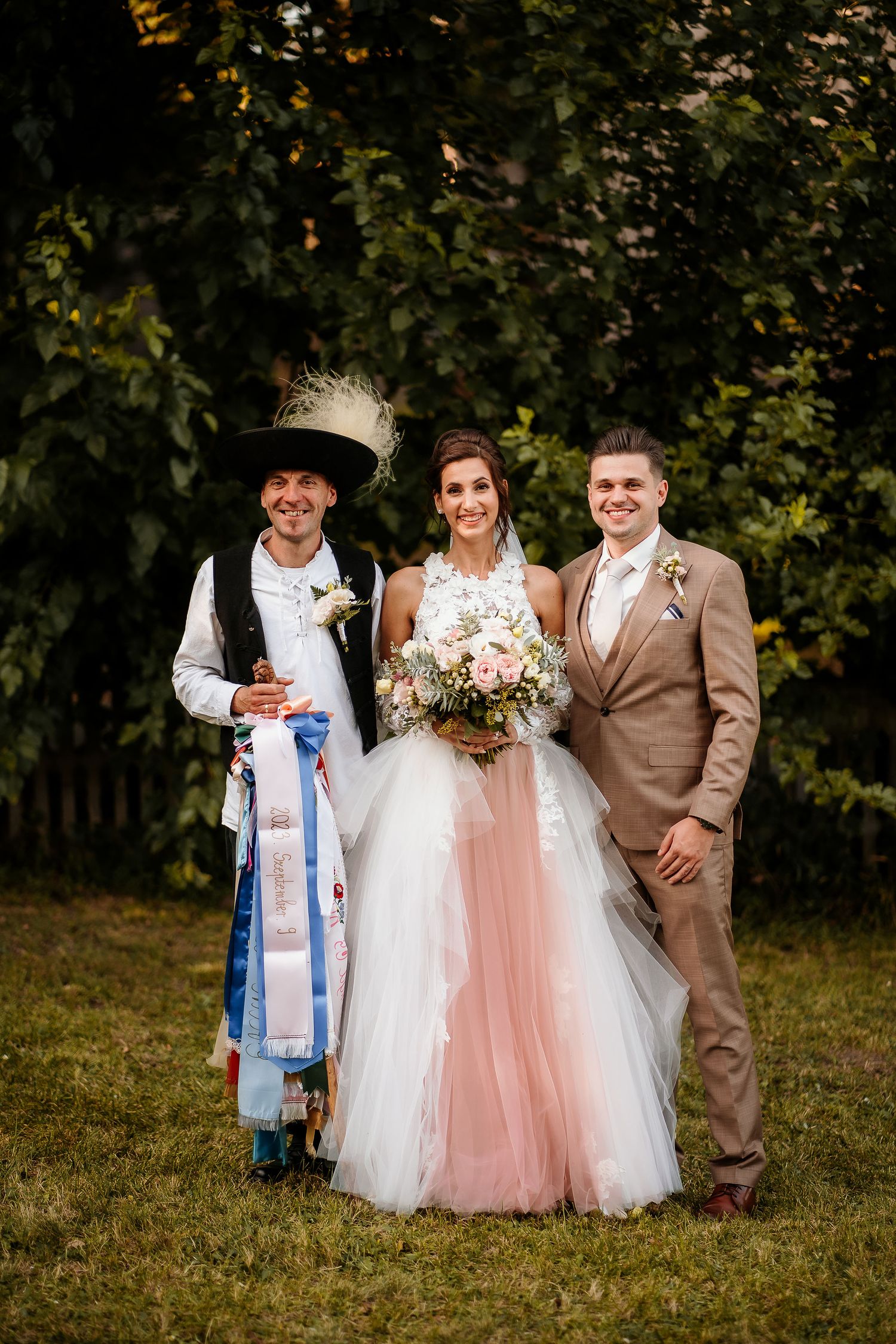 Traditional wedding portrait featuring couple with clergy member in ceremonial robes.