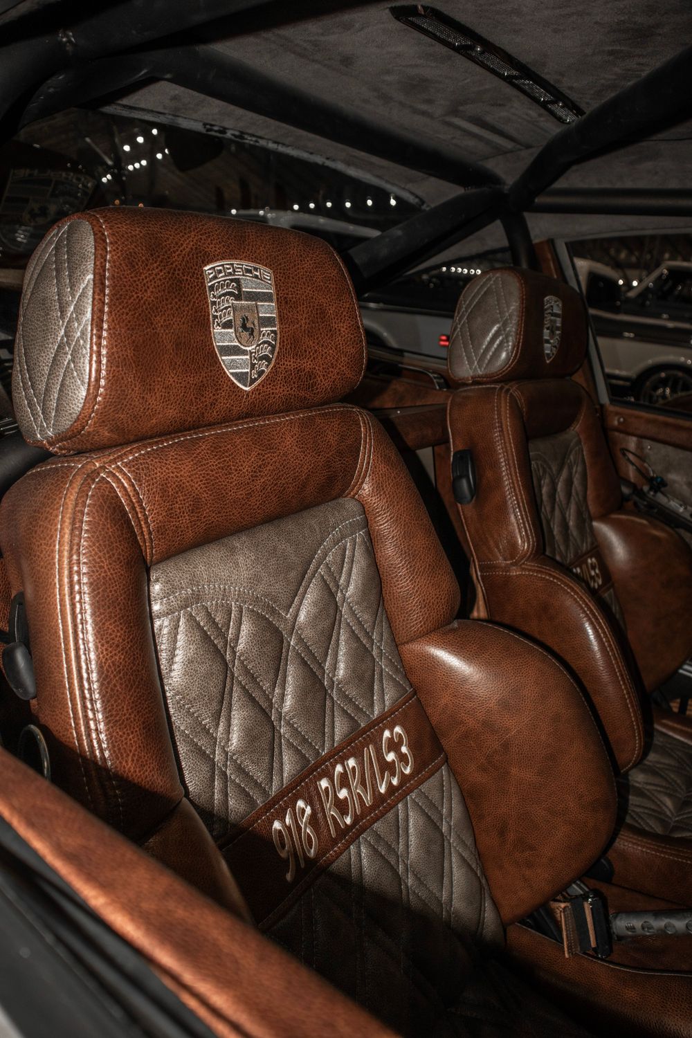 Luxurious brown leather Porsche interior with quilted seats and embroidered details.