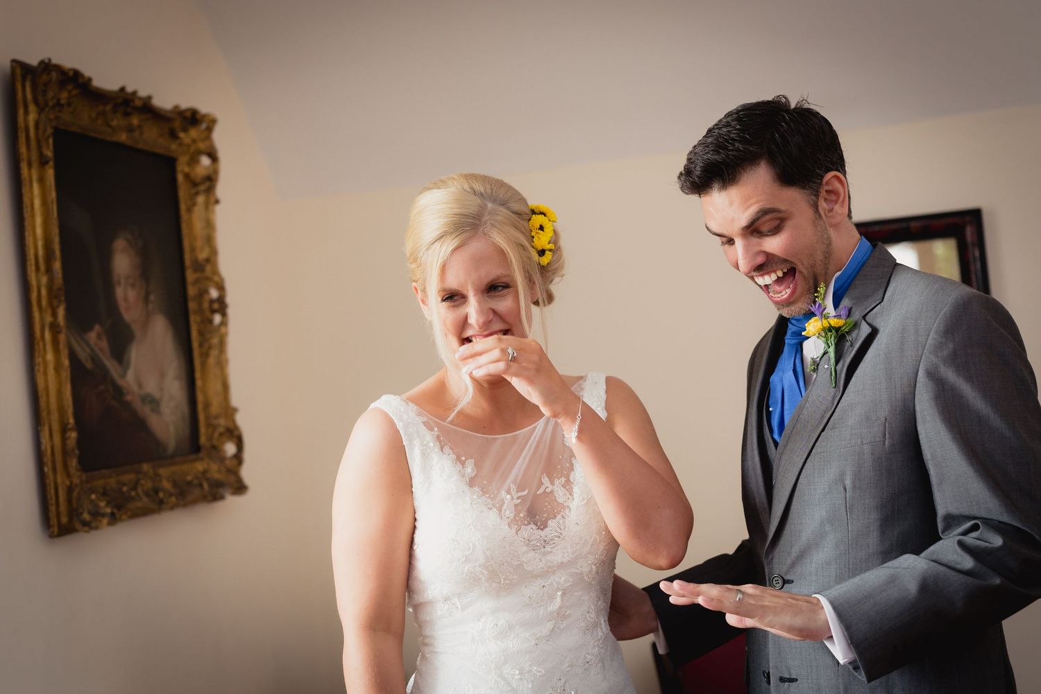 Wedding couple sharing emotional reactions while reading letters in an elegant room with framed artwork.