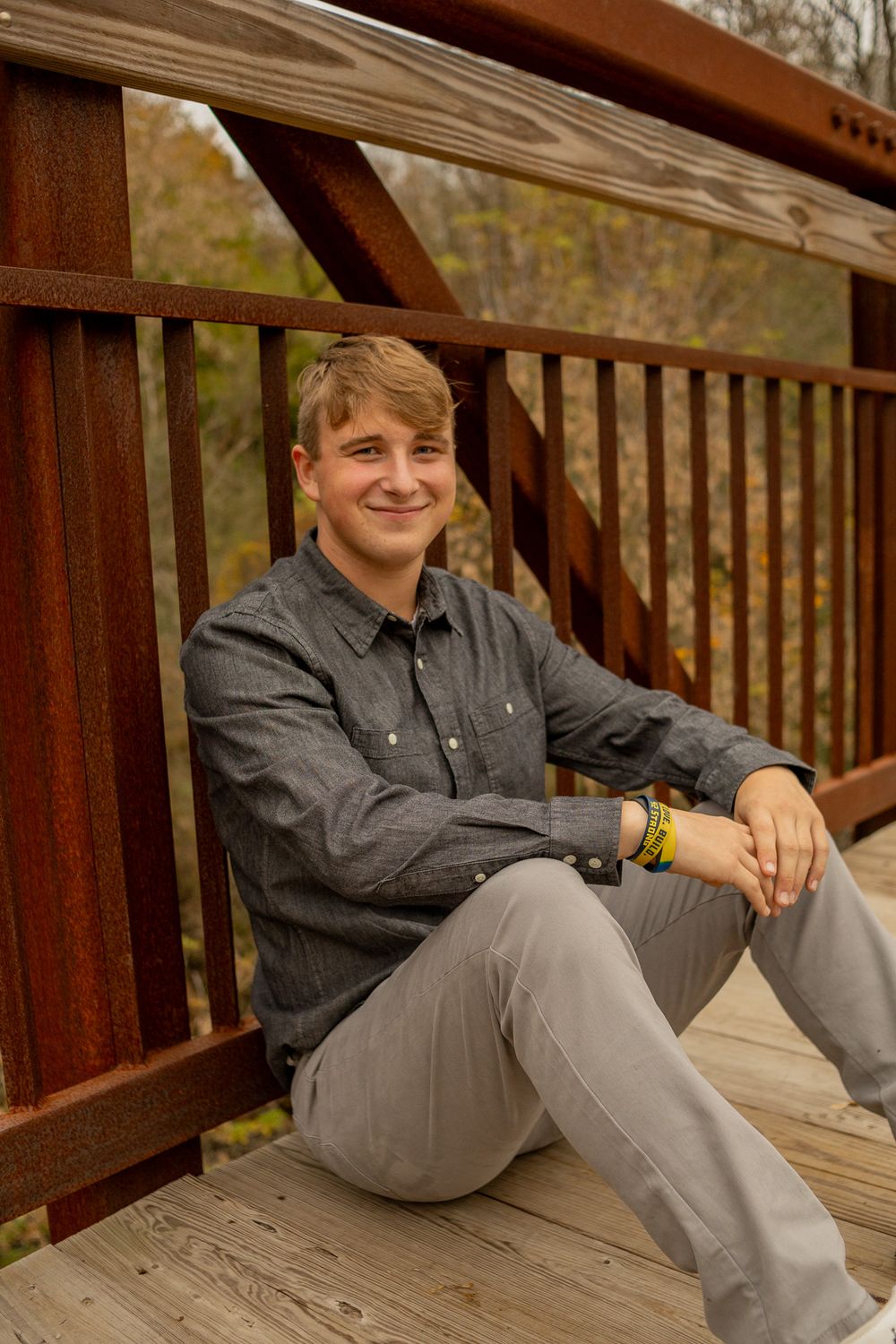 teenage boy leaning up against bridge