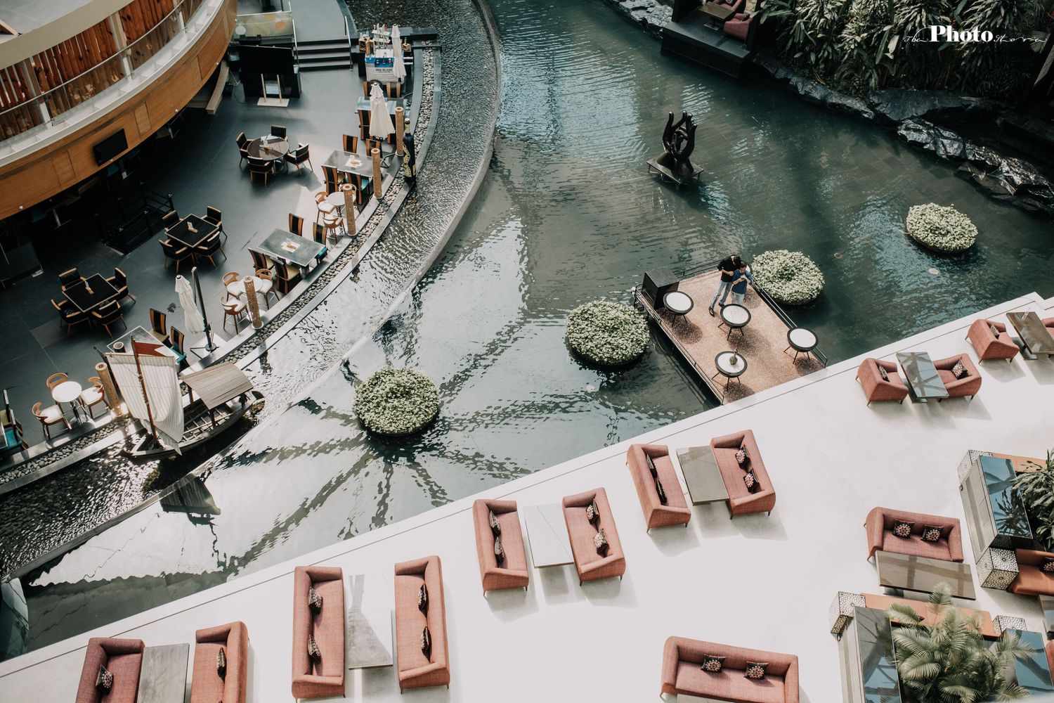 Bird's eye view of a mall atrium featuring water features and curved balconies.