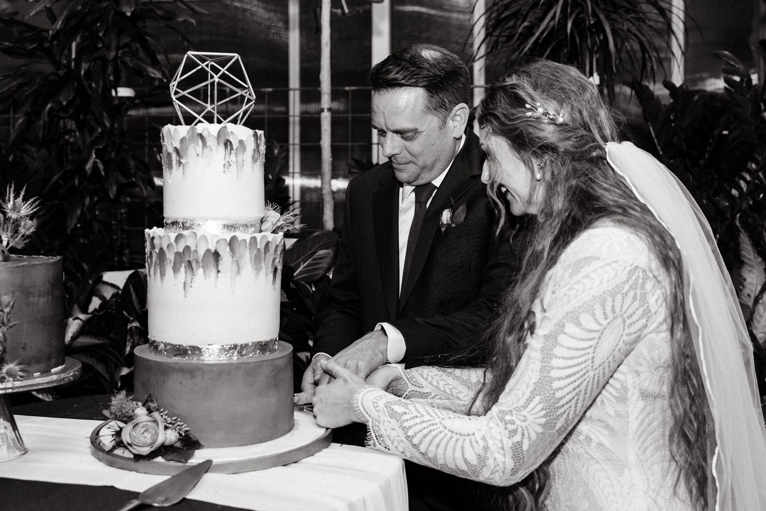 Bride and Groom cutting wedding cake in black and white