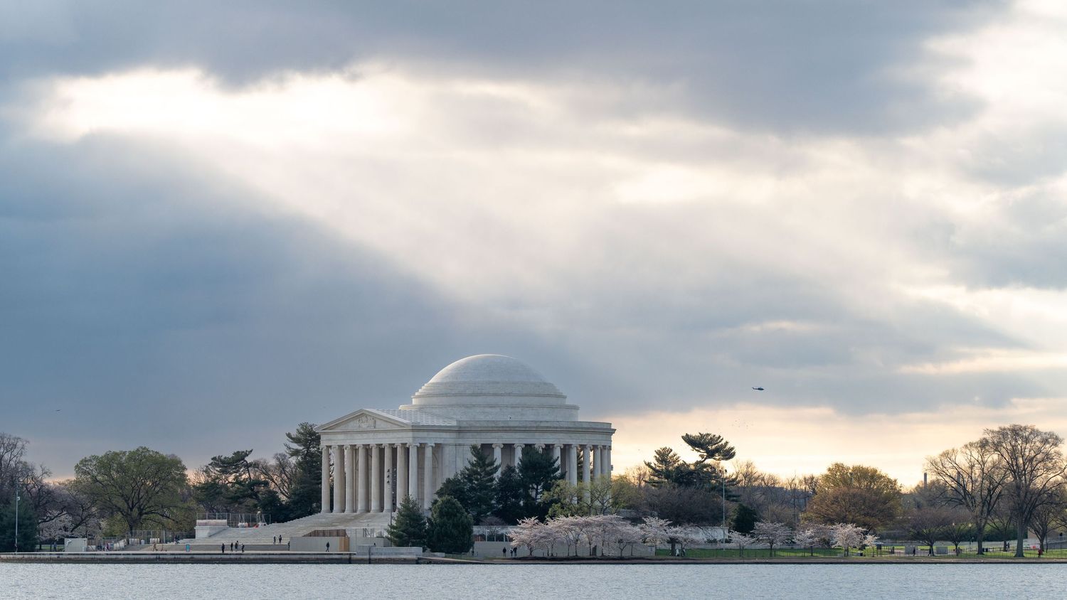 Jefferson Memorial reflected in the Tidal Basin under dramatic cloudy skies.