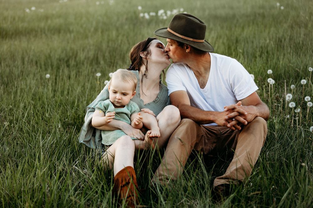 A sweet family moment shared in a wildflower meadow filled with dandelions.