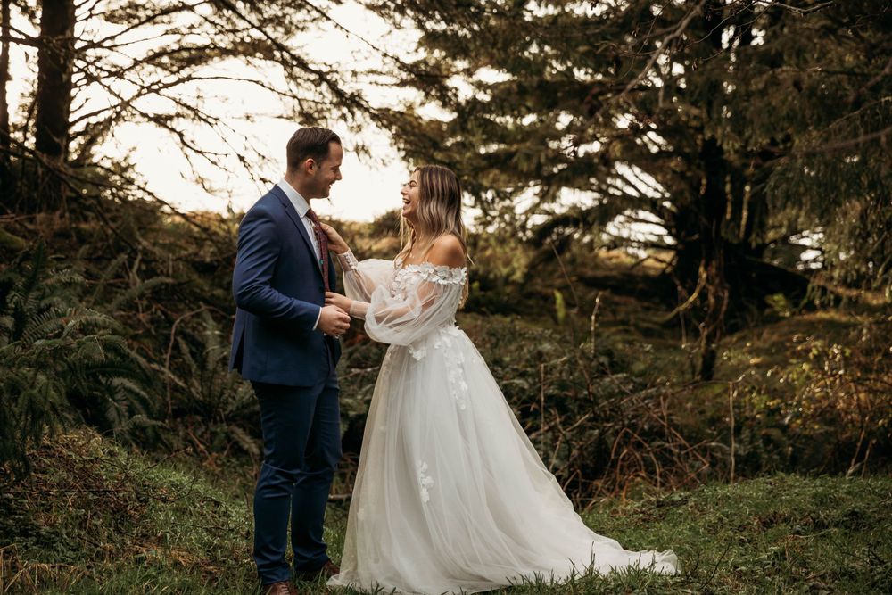 Wedding portraits in a lush evergreen forest during golden hour.