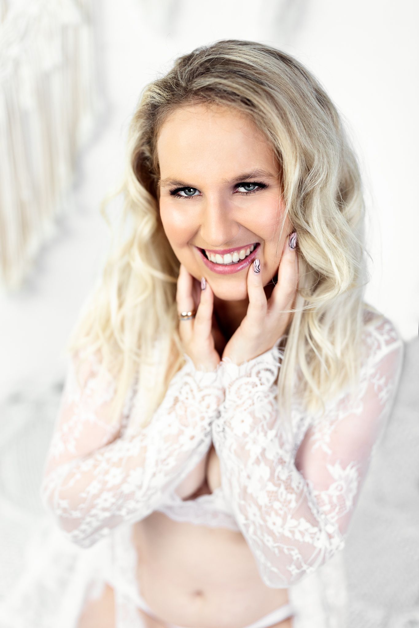 Intimate boudoir portrait series with white lace and natural lighting.