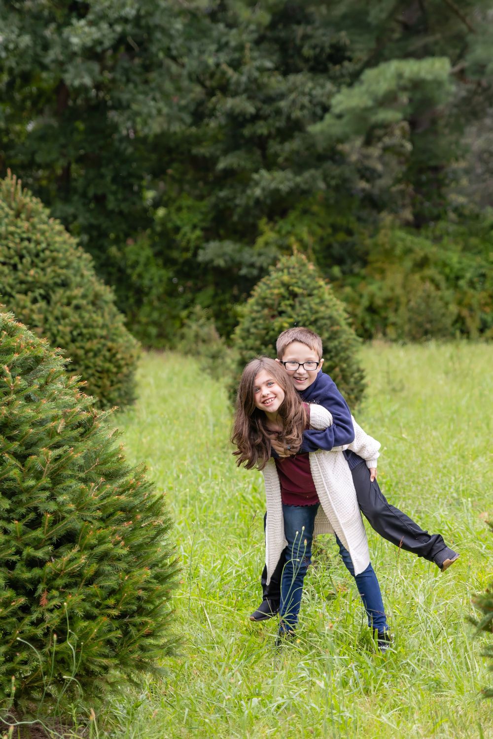 two kids standing in christmas tree farm at turkey trac farms in millville new jersey cumberland county