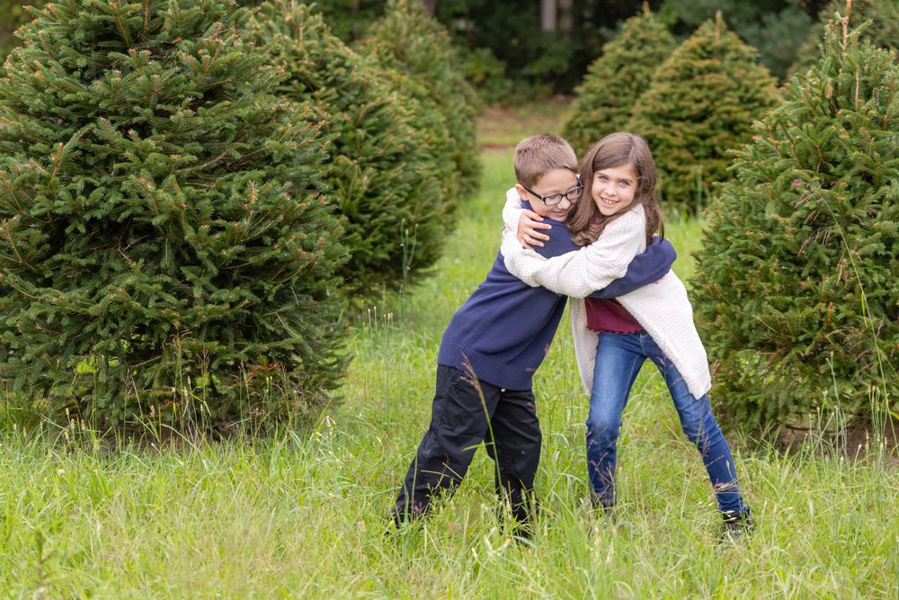 two kids standing in christmas tree farm at turkey trac farms in millville new jersey cumberland county
