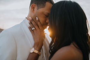 Romantic sunset engagement photo of couple in white attire.