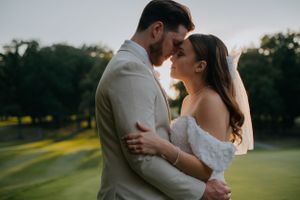 Romantic sunset moment between couple in formal wear on a golf course.