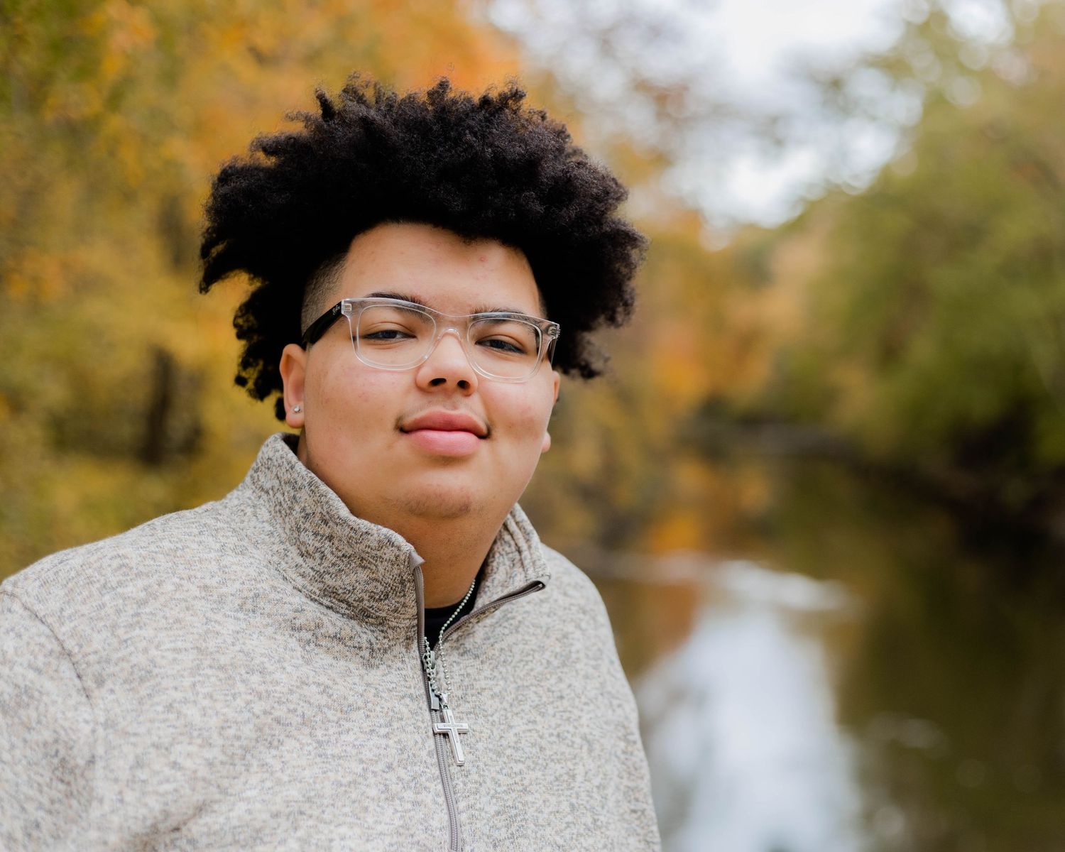 A series of autumn portraits with a cozy sherpa jacket and glasses against a blurred fall background.