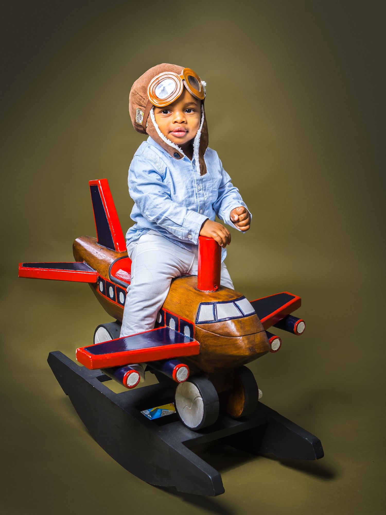 Little boy in pilot hat on a rcoking plane