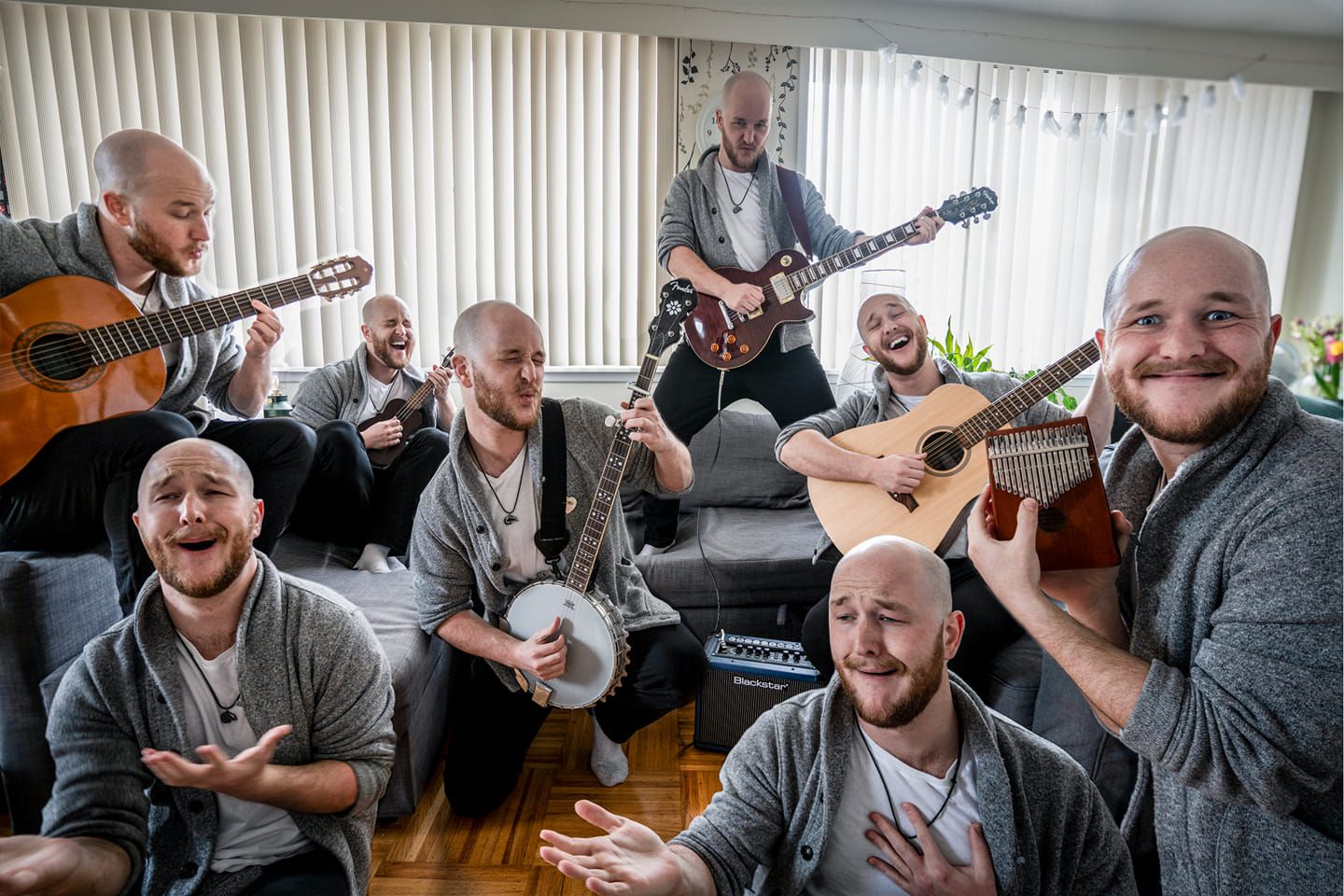 Group of musicians playing acoustic instruments together in a bright room.