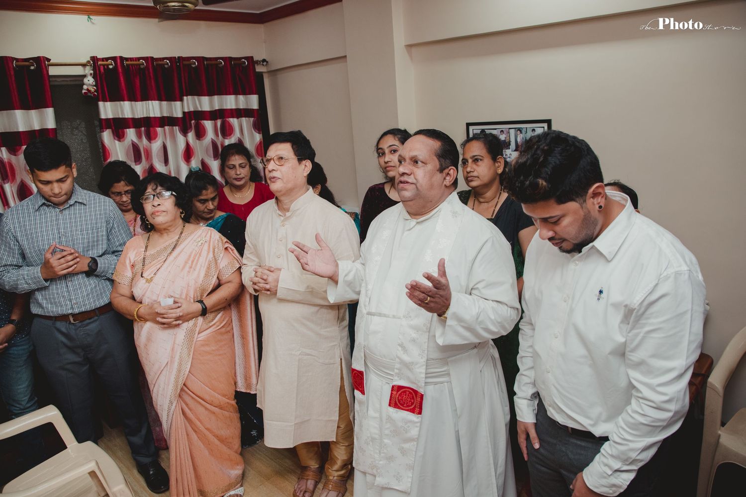 Indoor celebration with people in white shirts gathered in a casual setting.