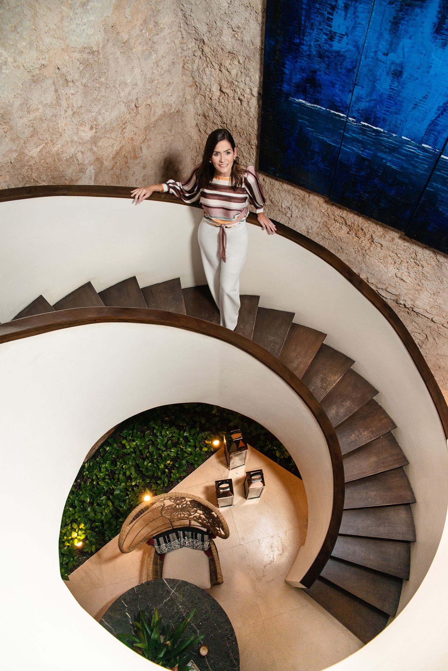 An artistic spiral staircase photo with white walls and wooden steps.