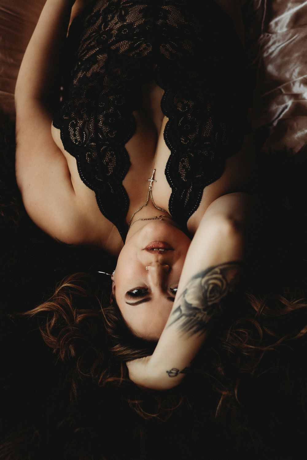Overhead boudoir portrait in black lace with dramatic lighting.