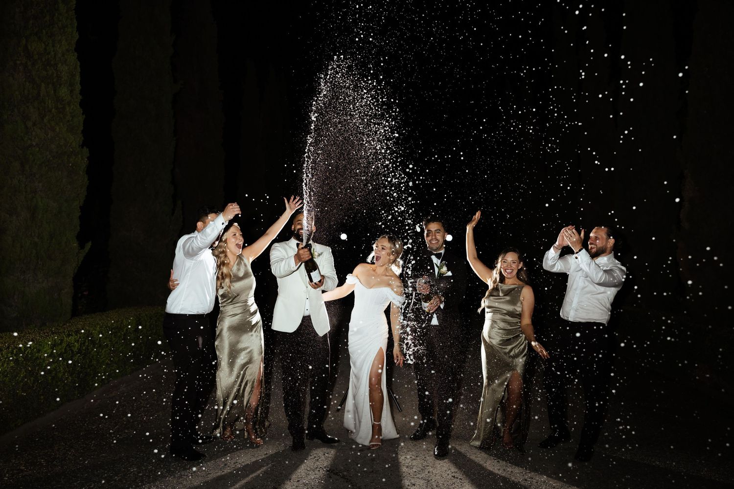 Wedding party celebration with sparklers creating a magical nighttime scene.