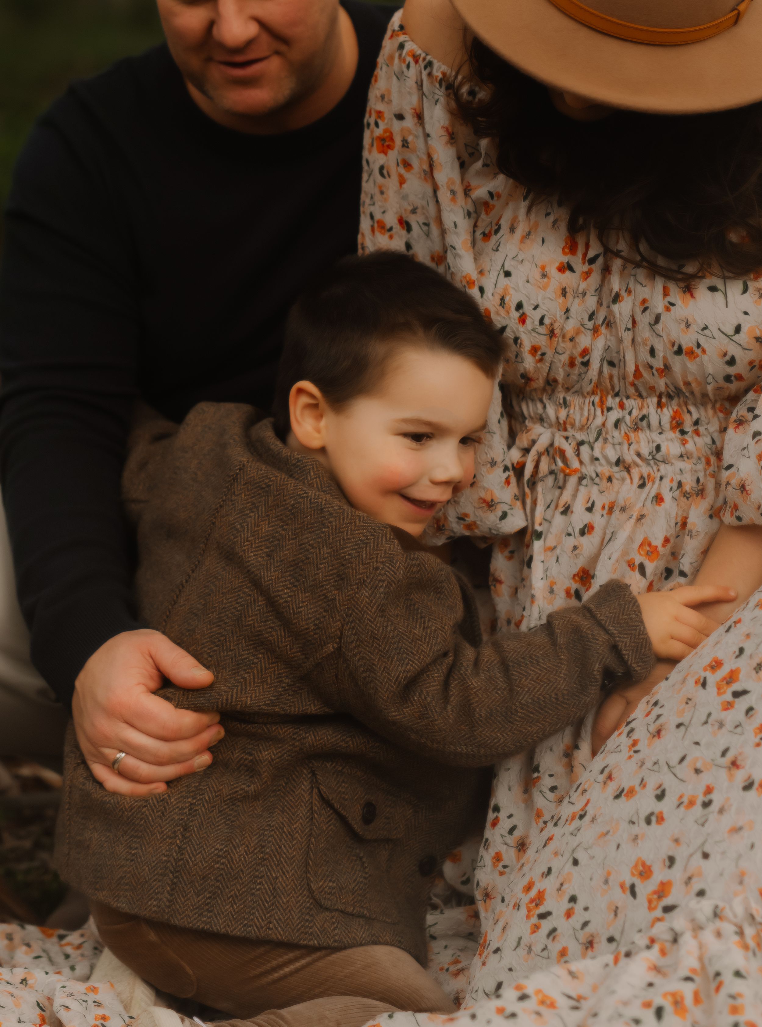 Intimate family portrait showing playful interaction and laughter in natural lighting.