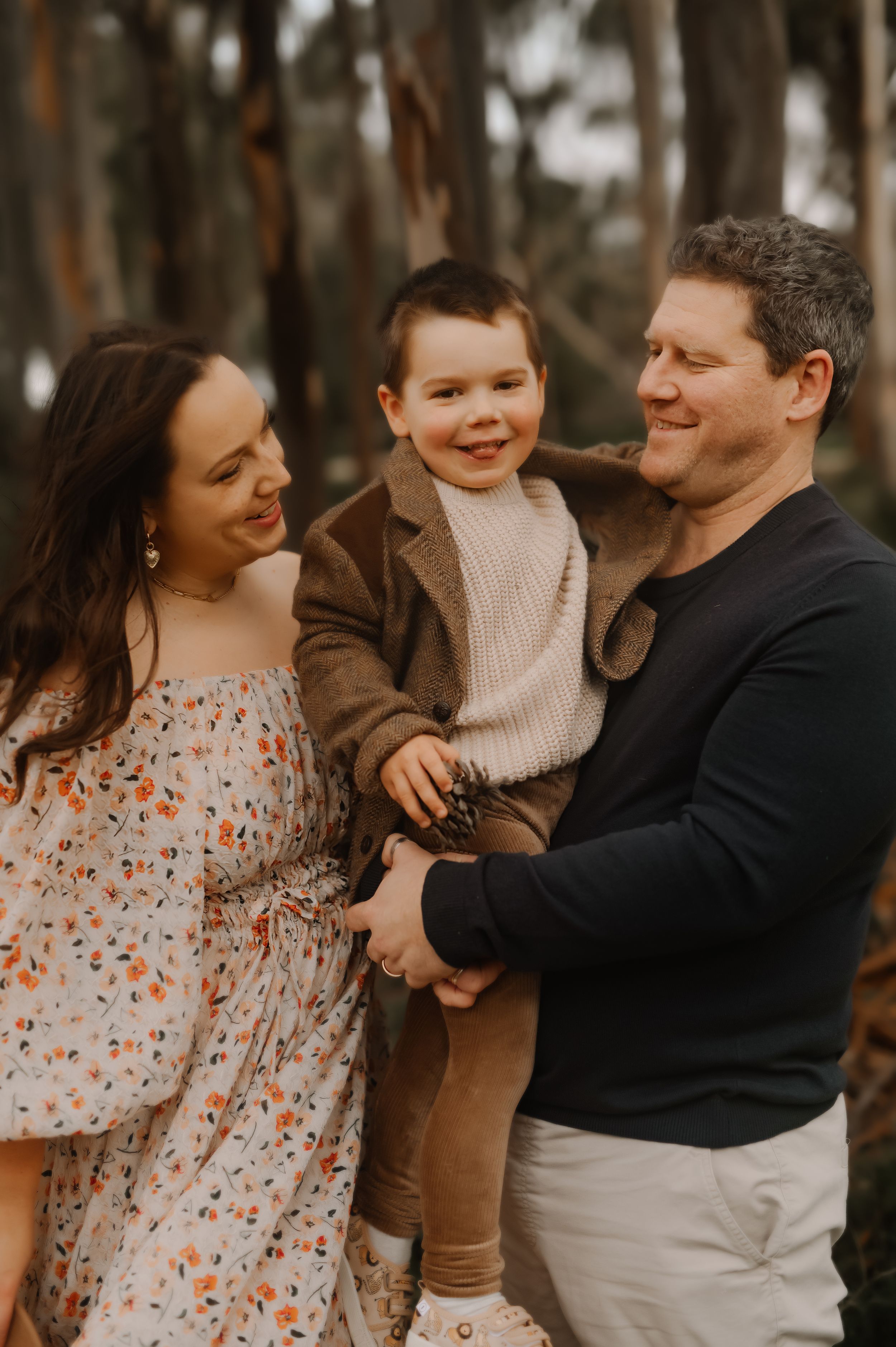 Playful family photographs showing intimate moments of joy and connection in a forest setting.