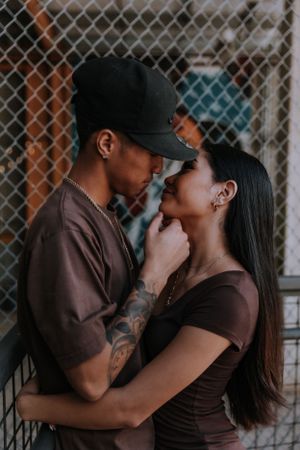 Intimate couple photography sequence showing tender moments against an urban fence backdrop.