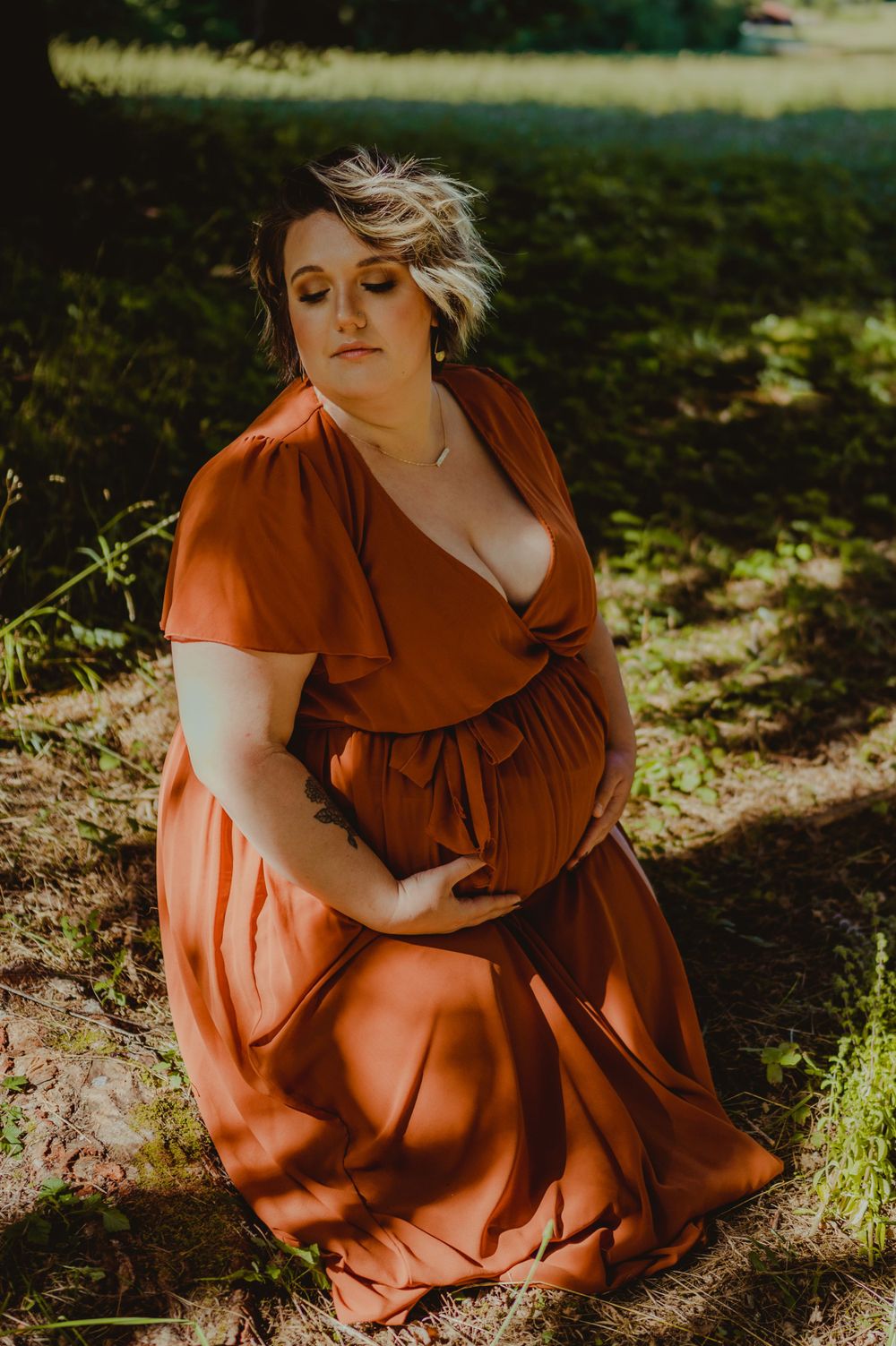 Warm sunlit portrait session featuring a rust-colored dress in a natural outdoor setting.