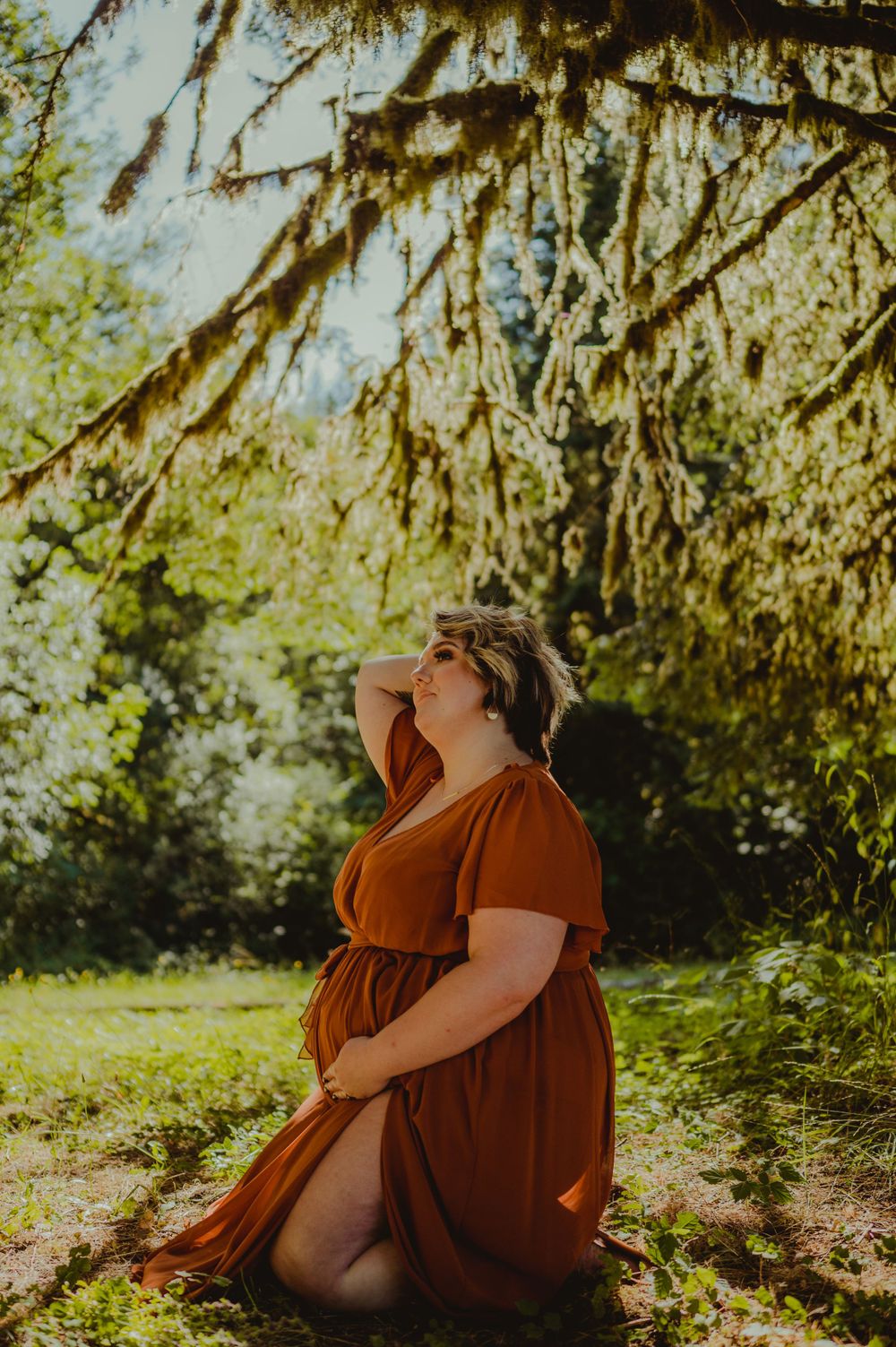 A rustic outdoor photoshoot featuring a rust-colored dress against a sunlit natural backdrop.