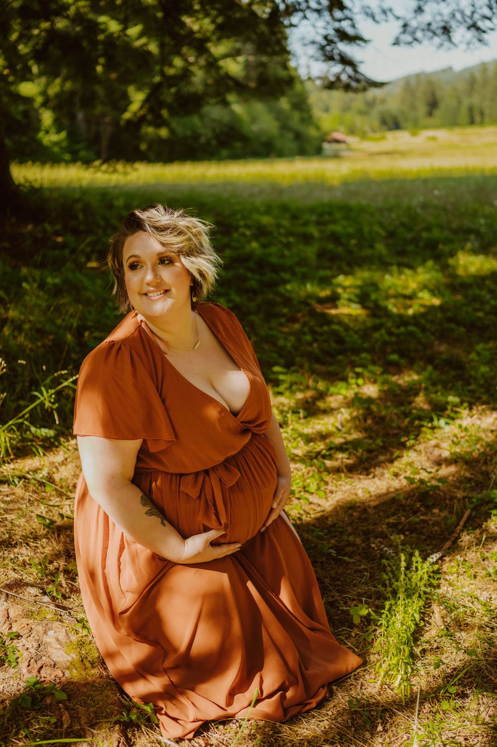 Natural light photography featuring a rust-colored dress in a sun-dappled meadow setting.