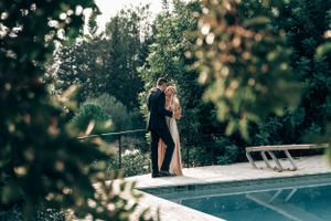 A romantic couple embracing each other by a poolside during an intimate boutique wedding celebration in Mallorca.