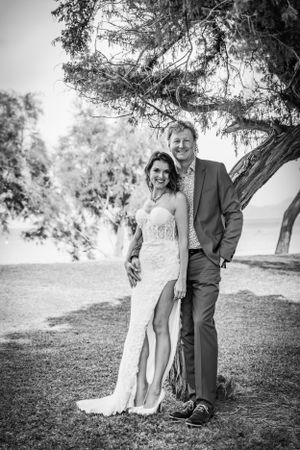 Timeless black and white wedding portrait of a bride and a groom under a trea at a boutique wedding in Mallorca.