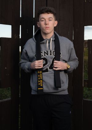 Athletic wear photo featuring grey Senior 24 sweatshirt against wooden background.