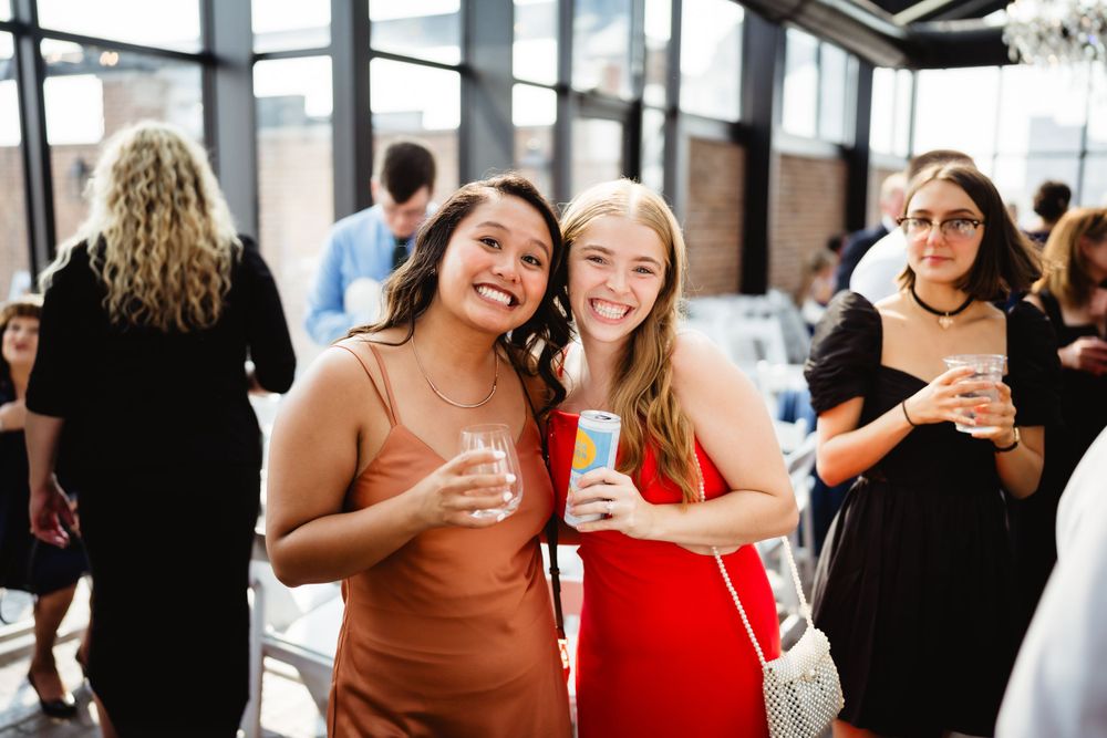 Wedding guests enjoying drinks and conversation at an indoor reception venue.