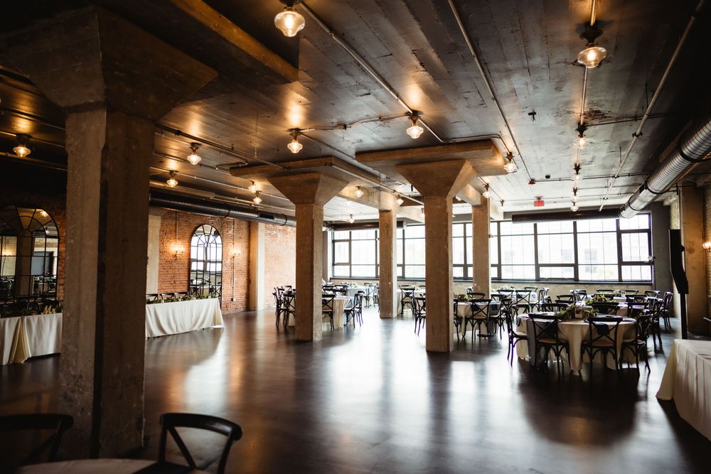 Industrial style wedding venue with exposed brick, columns and large windows.