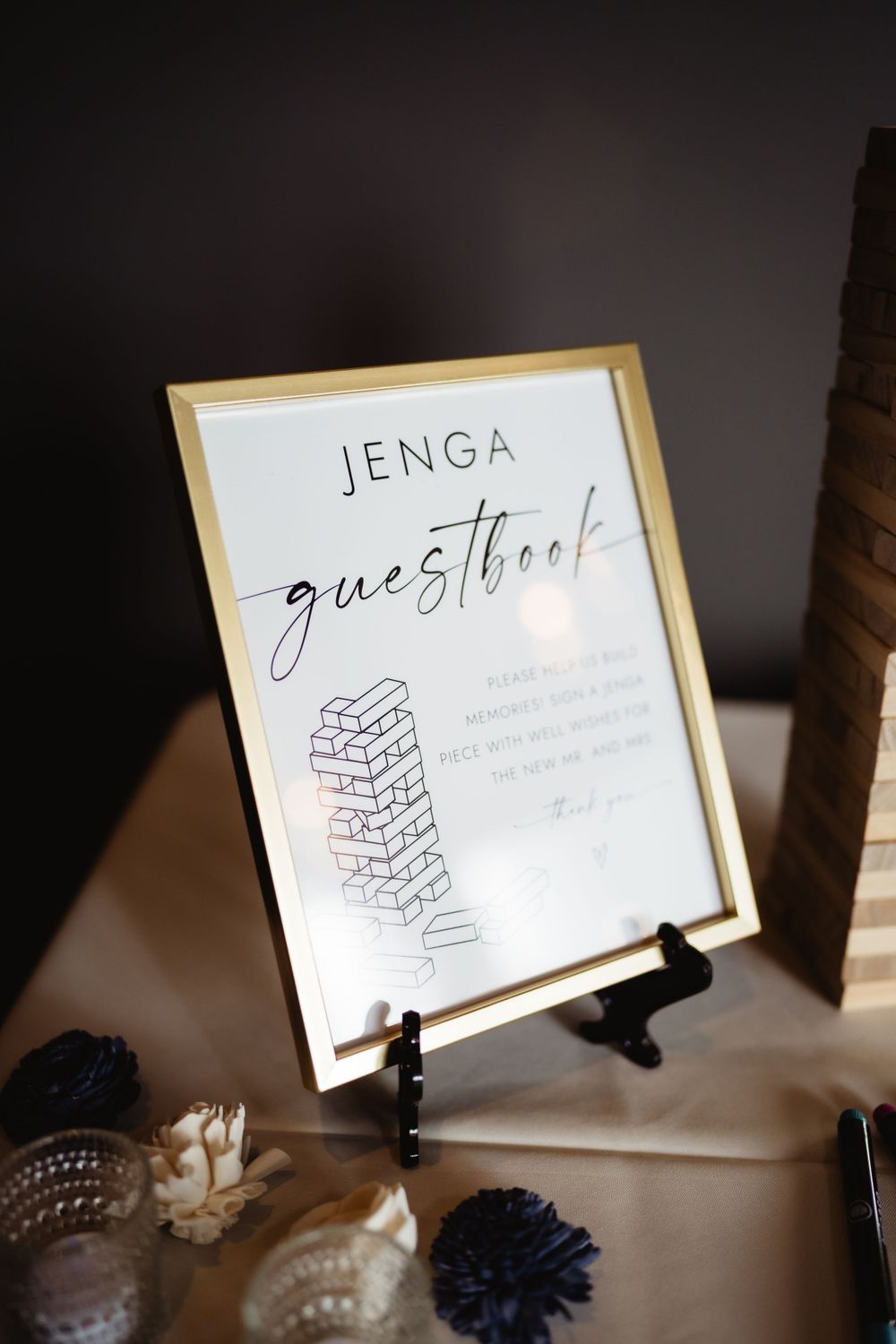 Wedding reception Jenga guestbook sign display with decorative elements.