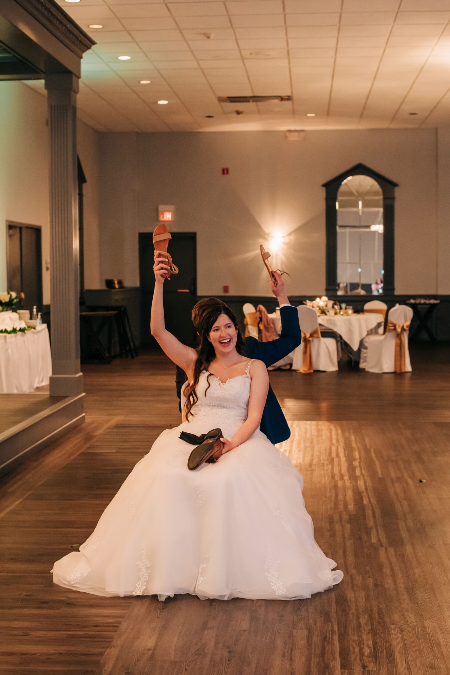 bride and groom playing the shoe game at a wedding reception