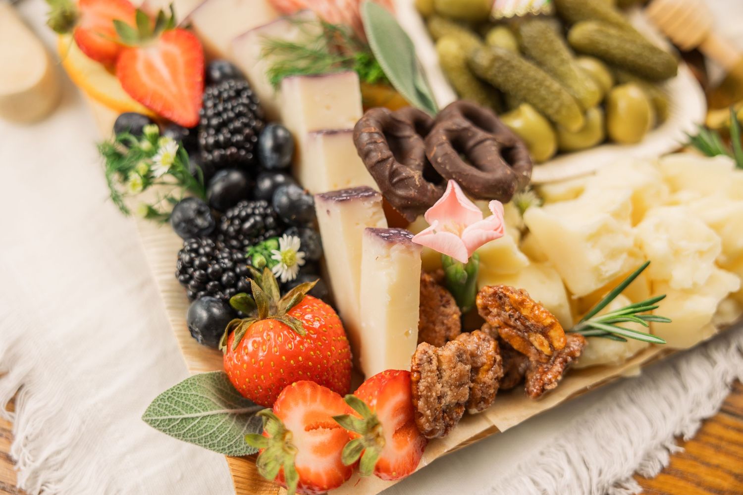 Close-up of charcuterie board with strawberries, blackberries, cheese cubes and cured meats.