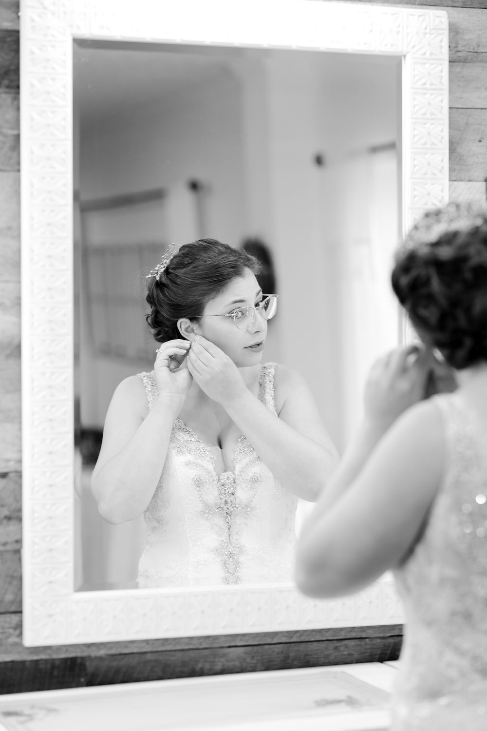 Black and white mirror reflection of wedding preparation moment.