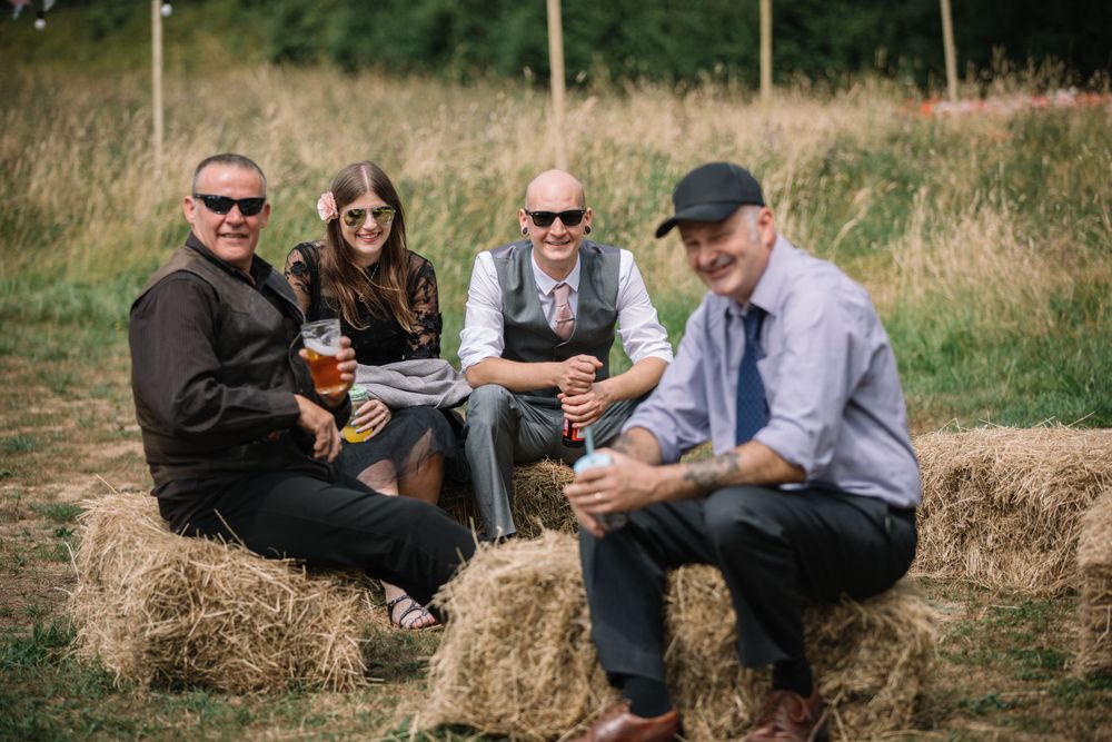 Guests relaxing on hay bales during an outdoor celebration.