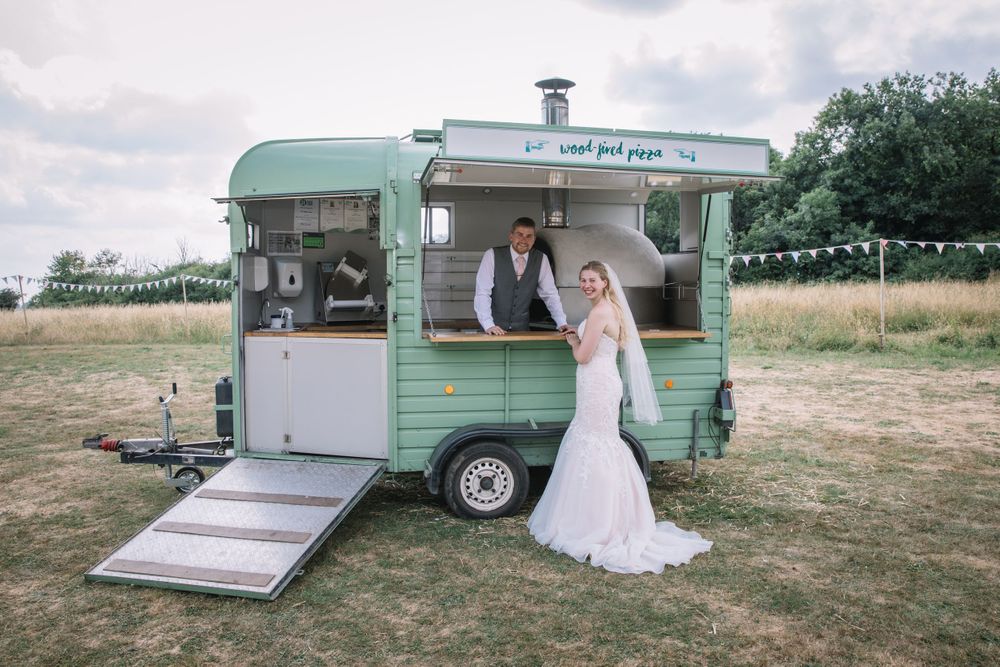 Vintage mint green food truck serves as unique wedding backdrop in countryside setting.