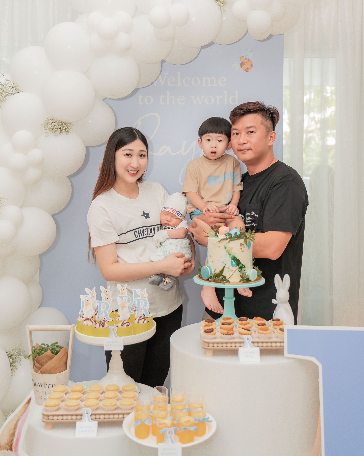 A celebration setup with elegant white balloon decorations and dessert display.