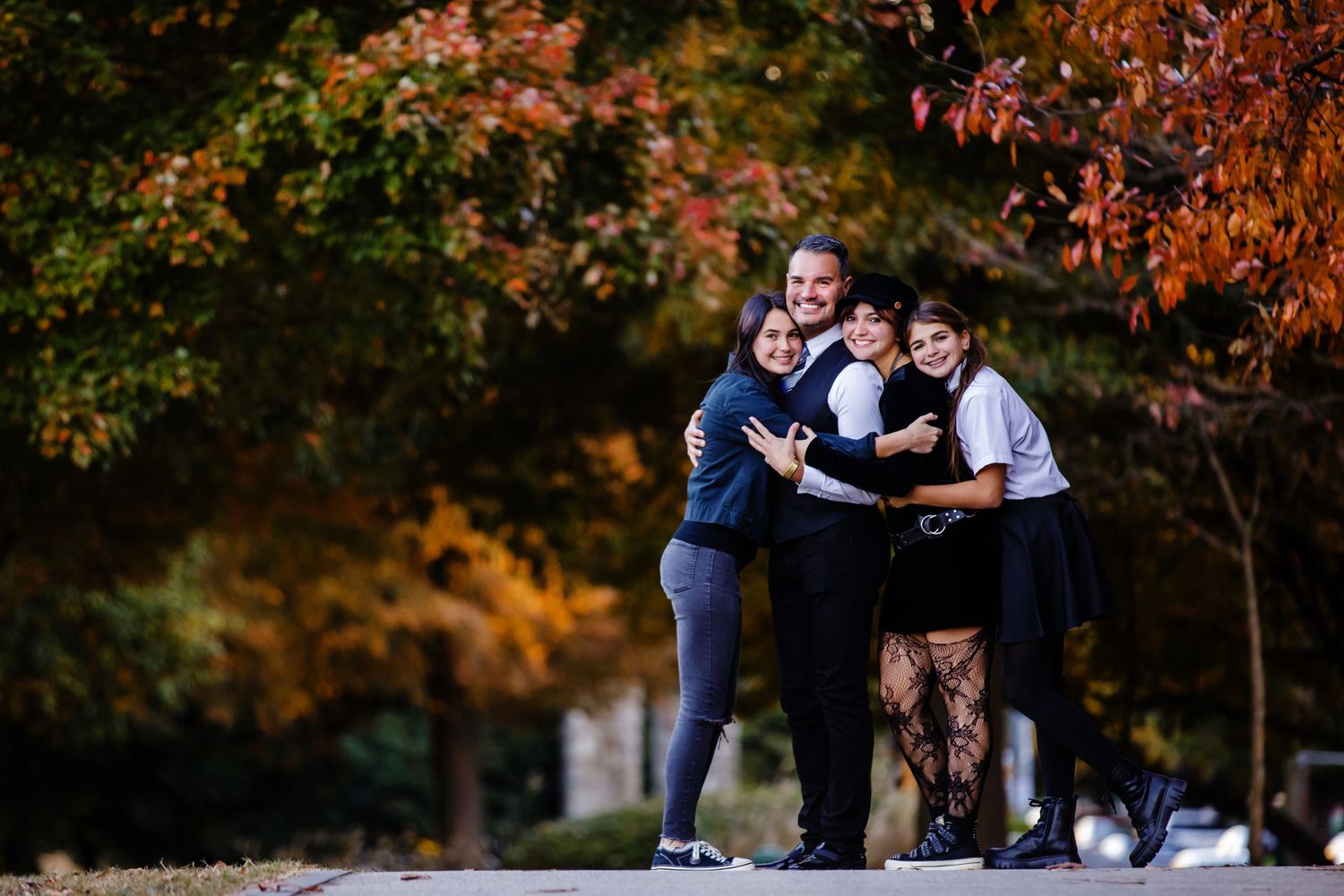 Three friends enjoying outdoor activities against colorful autumn trees at sunset.