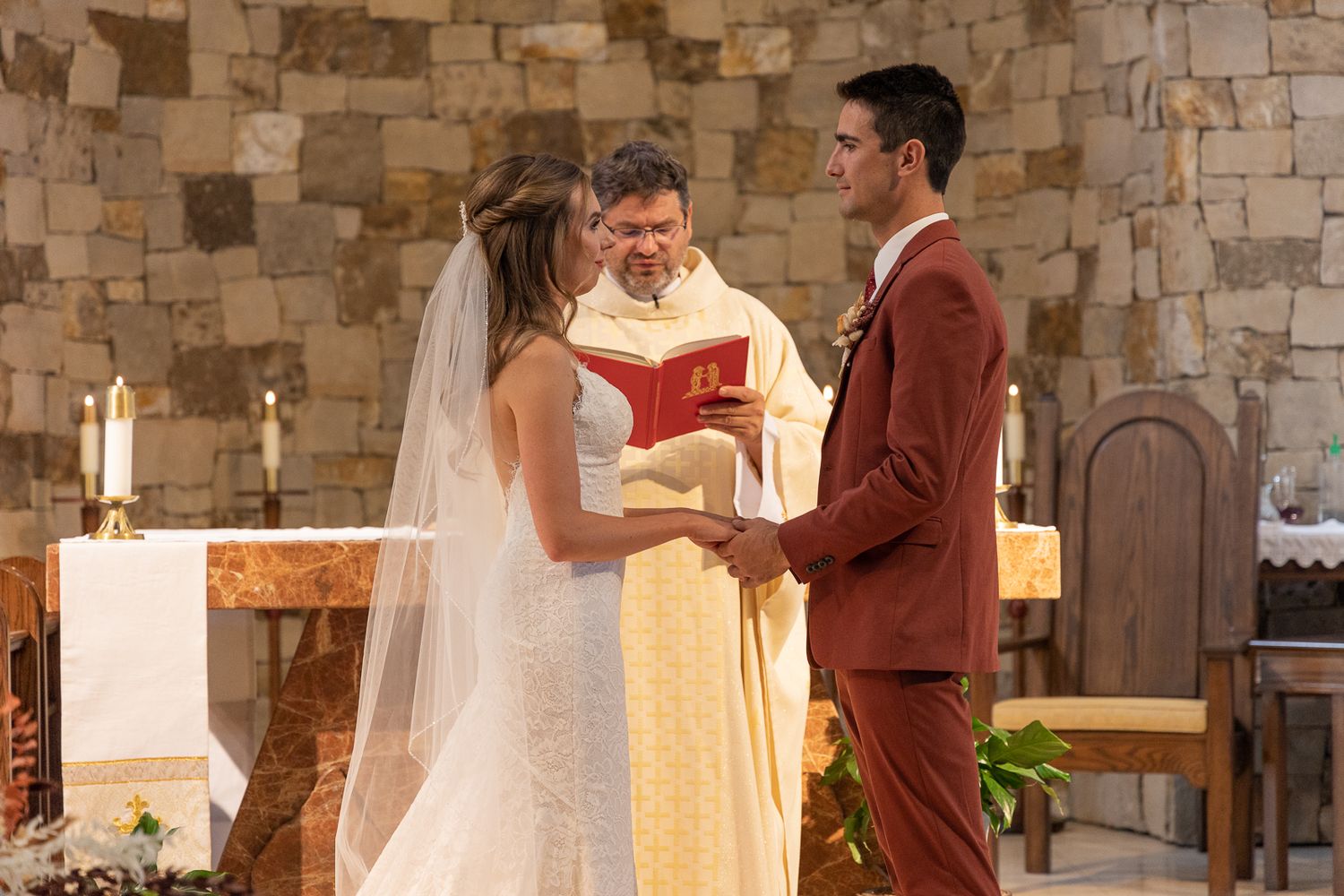 Traditional church wedding ceremony with burgundy and white attire.