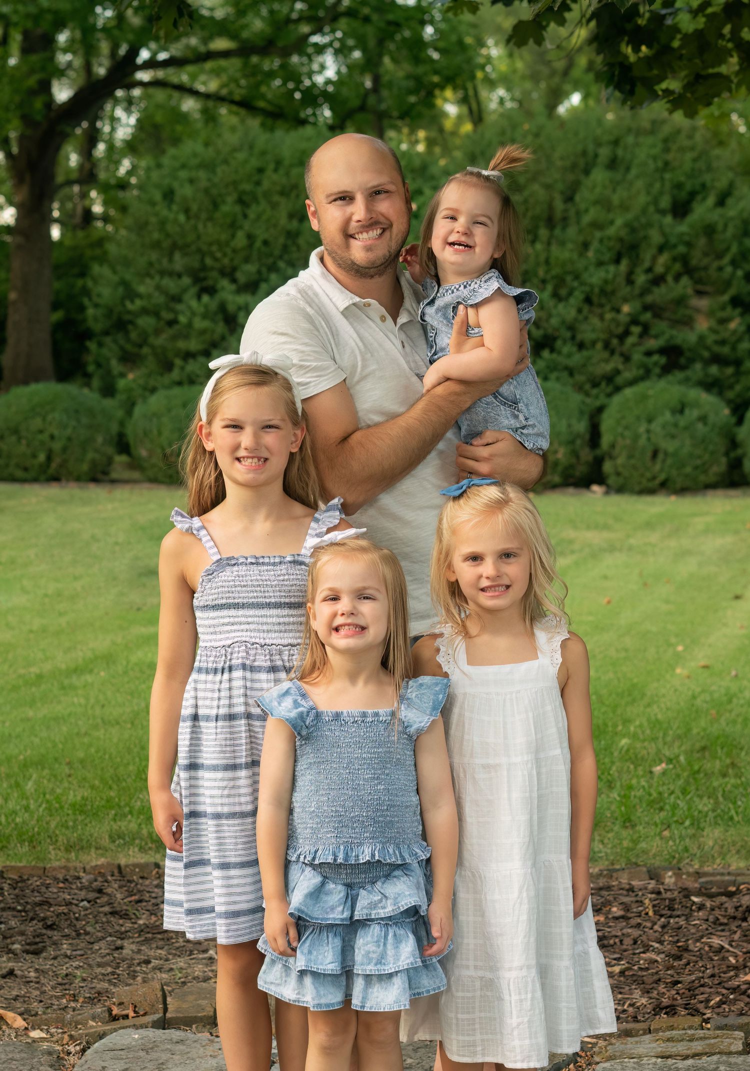 father and daughters smile together
