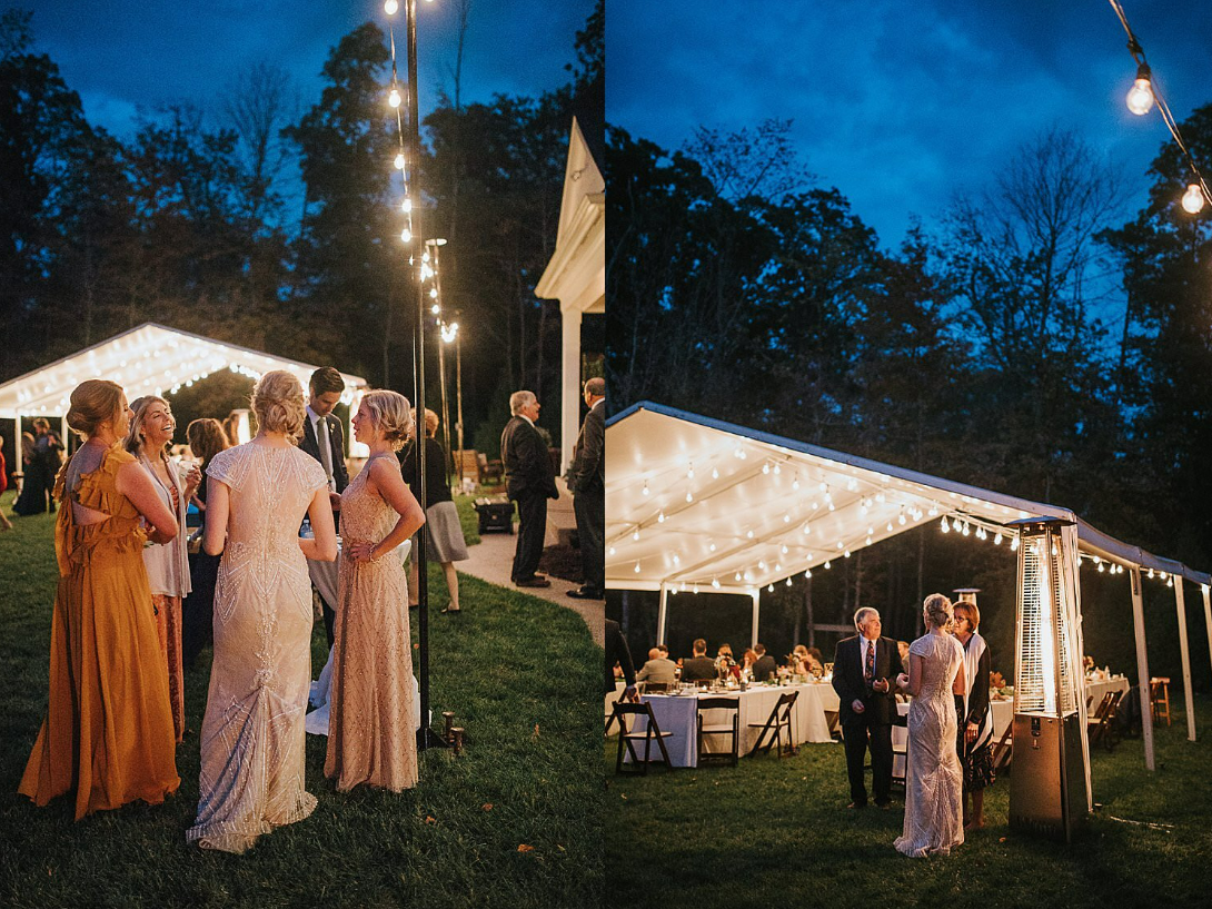 A nighttime outdoor wedding reception with illuminated tents and guests gathered under string lights.
