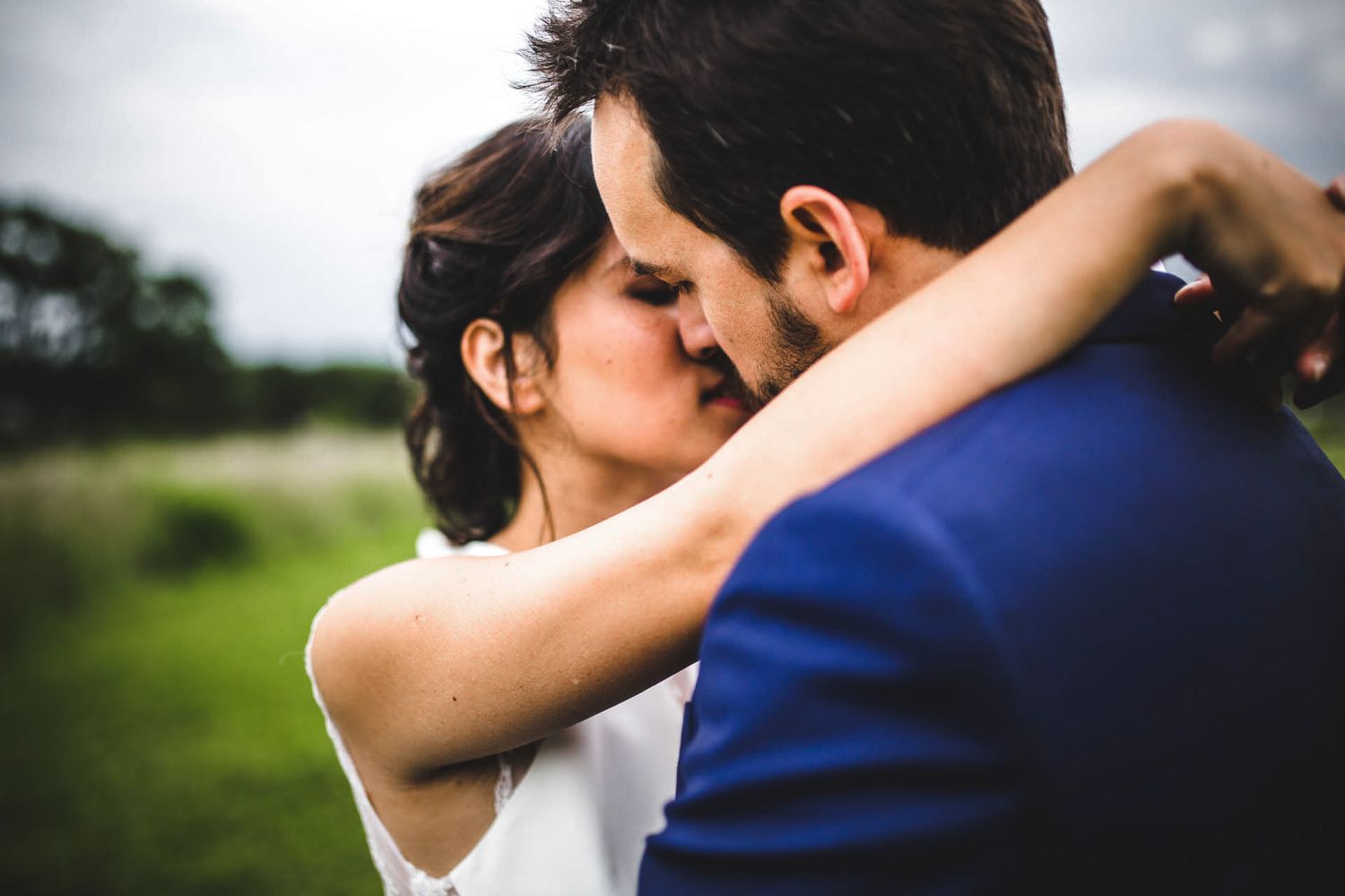 Close-up wedding photos showing intimate embraces against a natural outdoor backdrop.