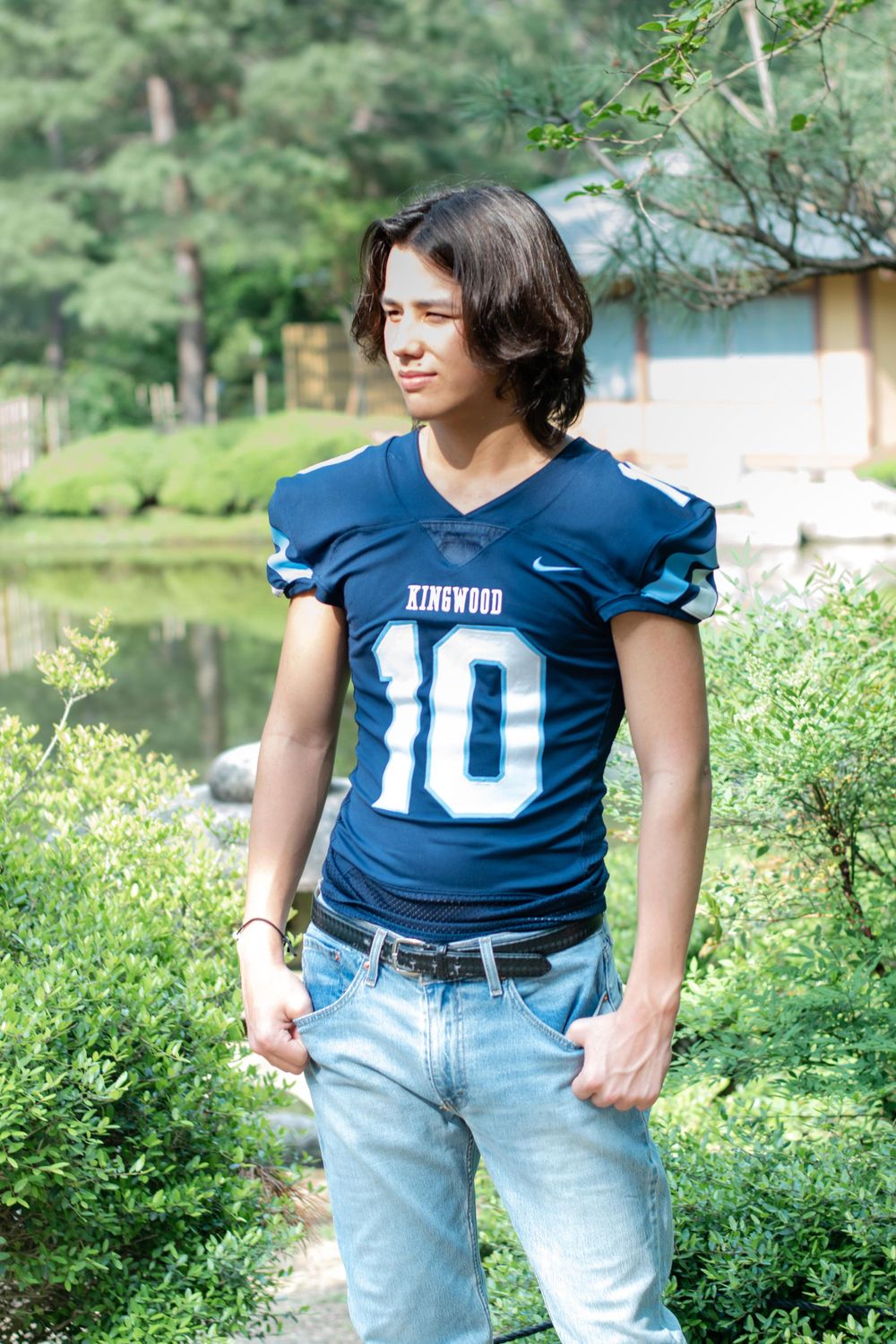 Portrait in blue football jersey number 10 with scenic garden background.