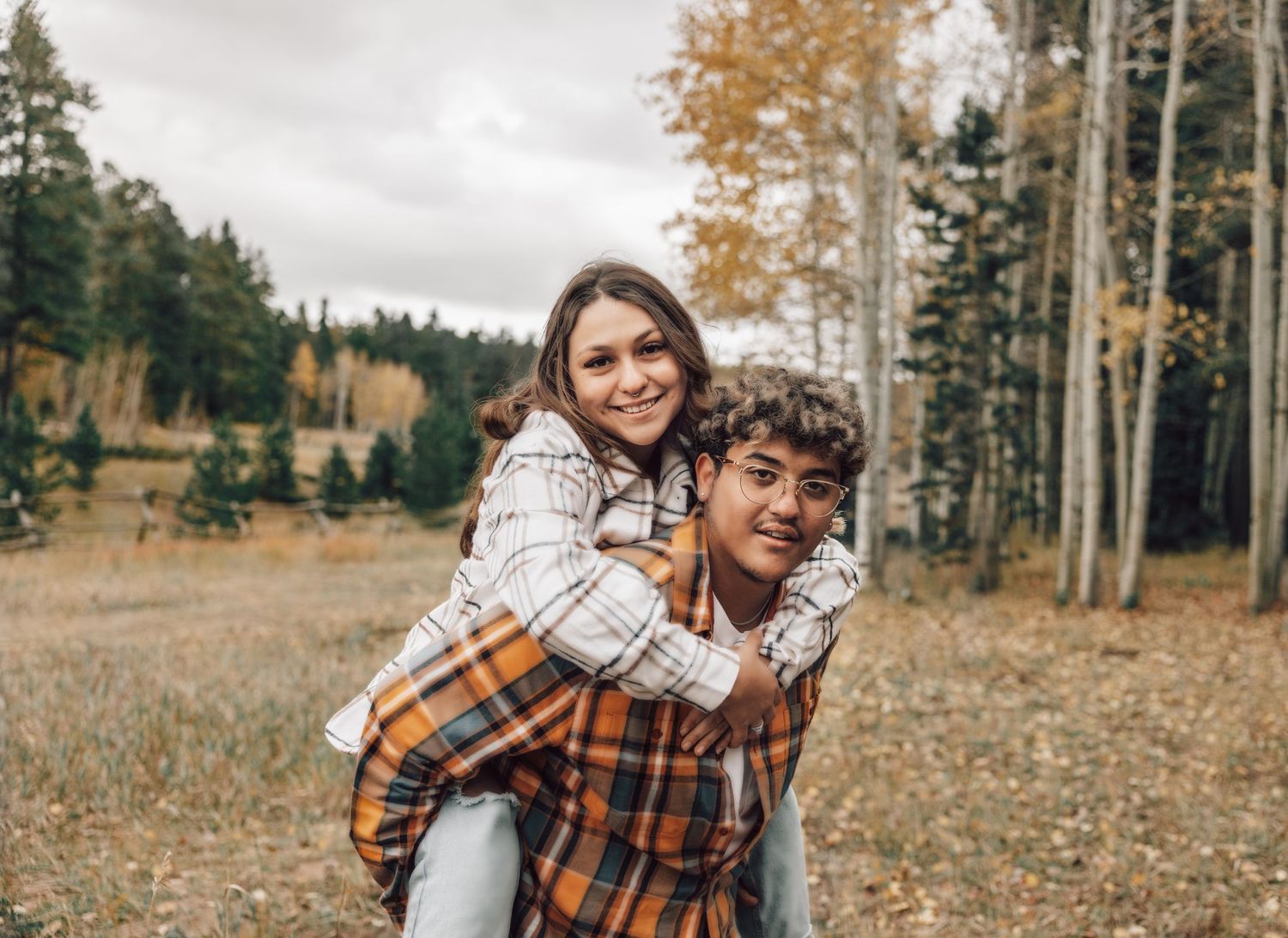 Boyfriend holding girlfriend on back, cute fall couple pose