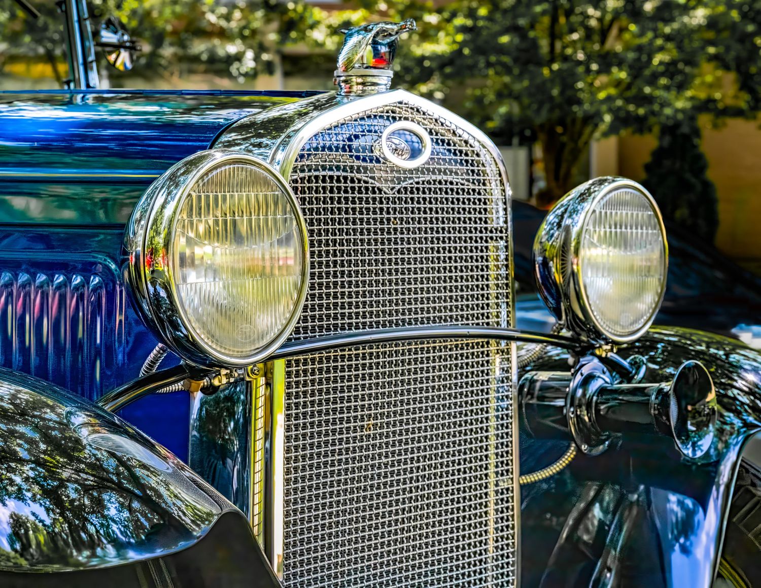 Close-up of a vintage car's chrome grille and headlights showing classic automotive design details.