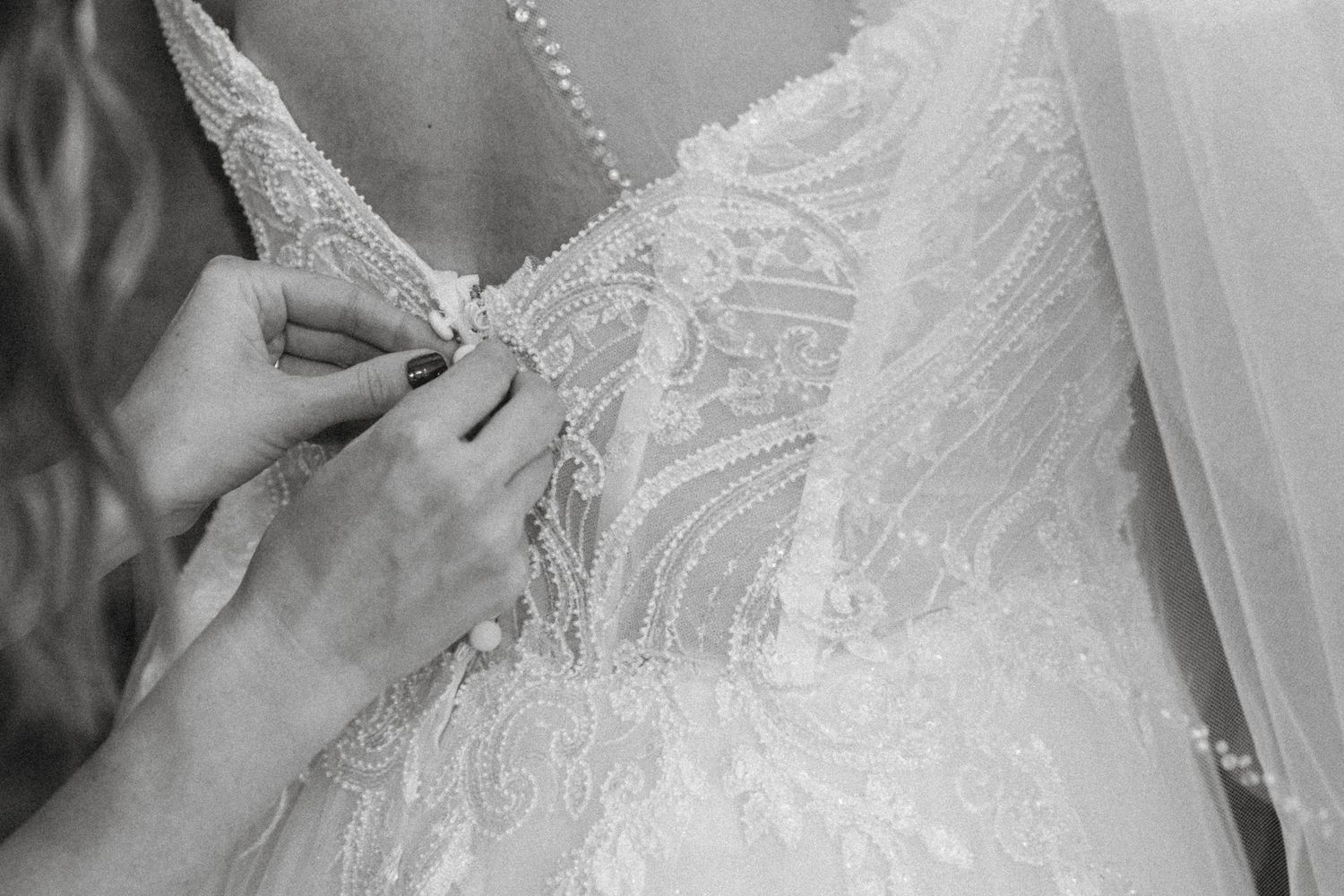 Mom of bride buttoning wedding dress