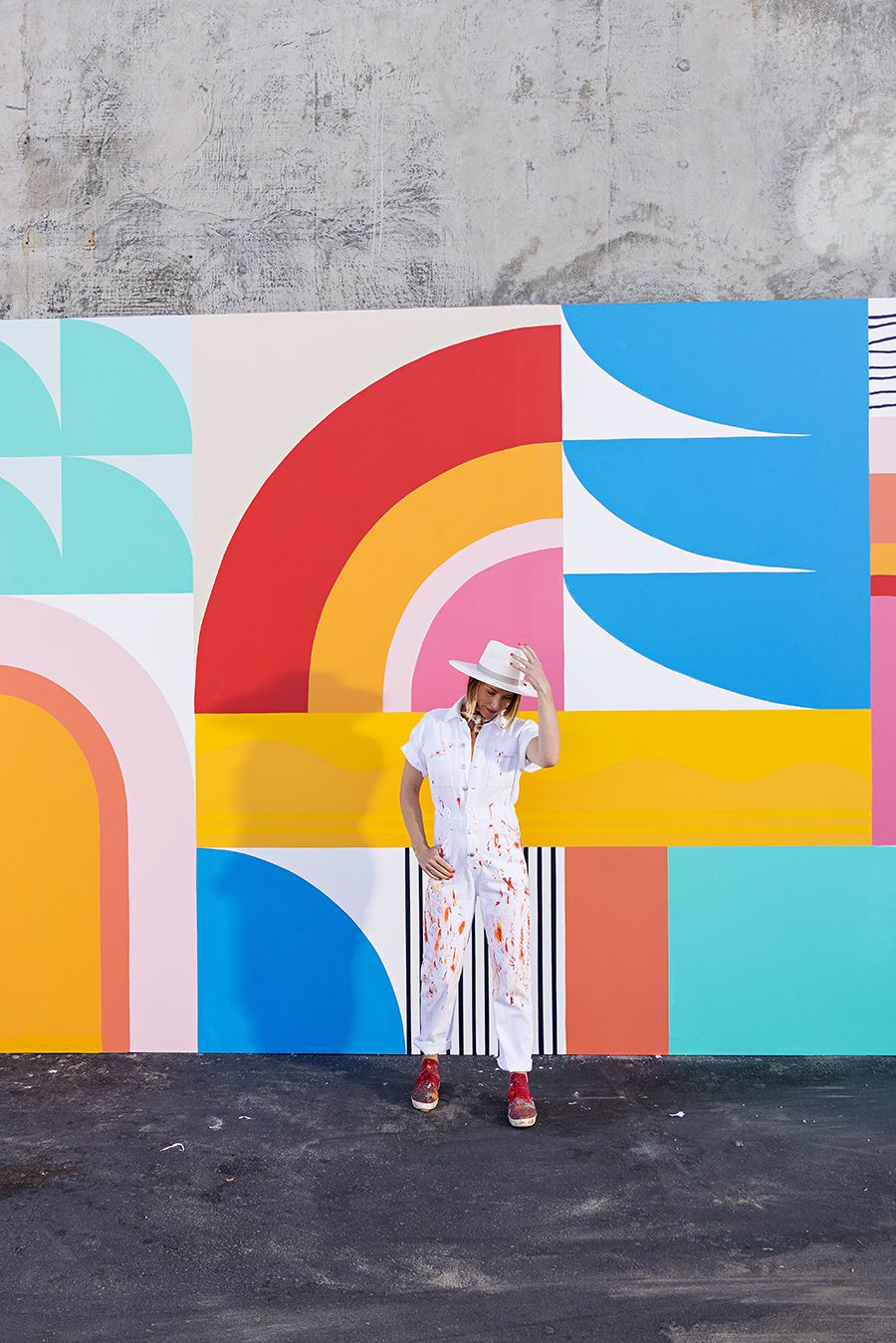 portrait of mural artist in front of colorful mural wall in Santa Monica California